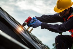 Worker installing metal roofing