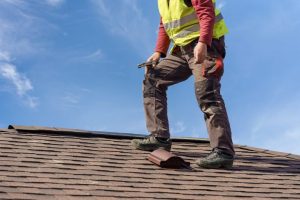 Roofing standing on apshalt shingle roof 