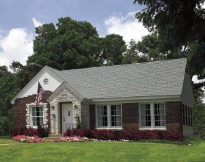 Brick home with landscaping and asphalt shingle roofing 