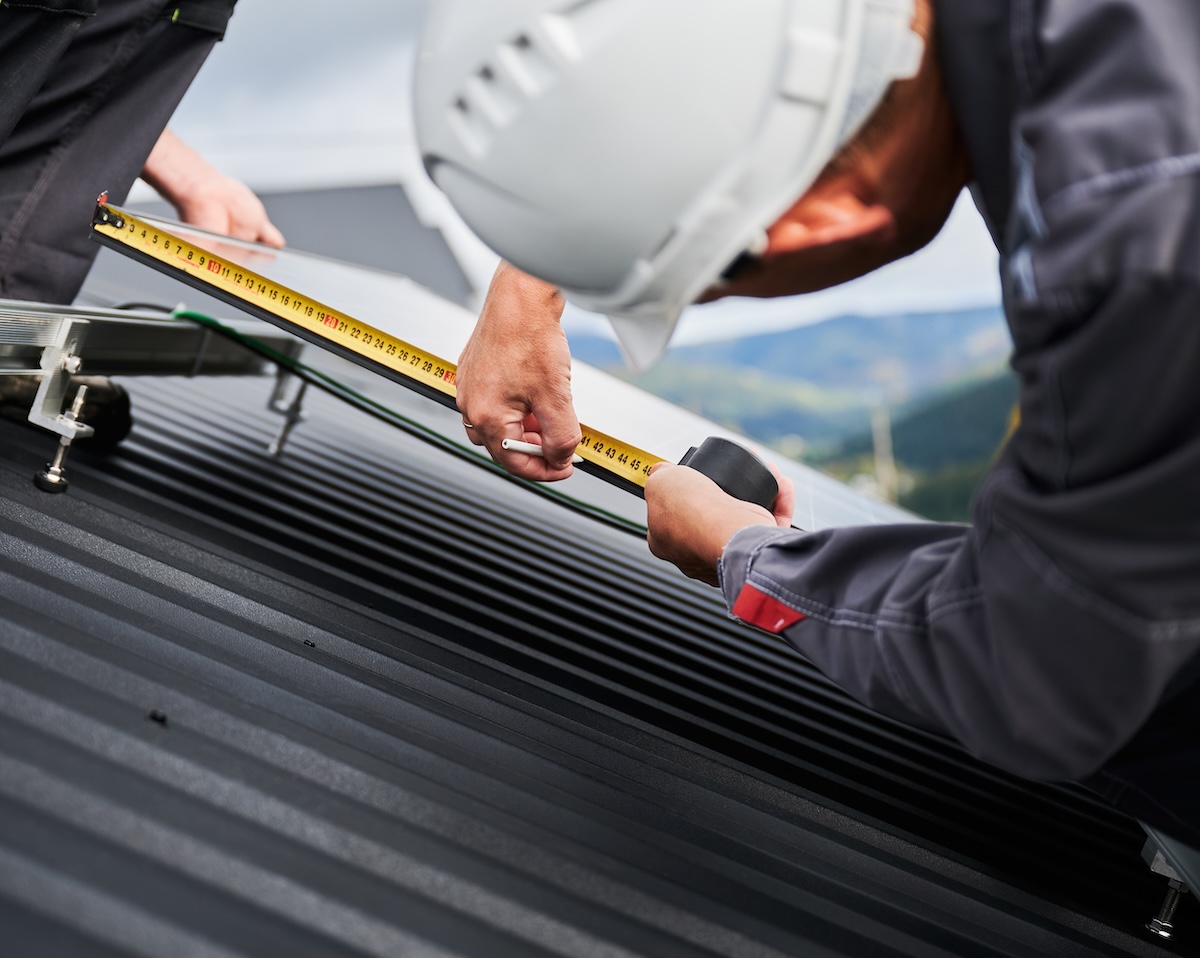 measuring a corrugated metal roof with a tape measure